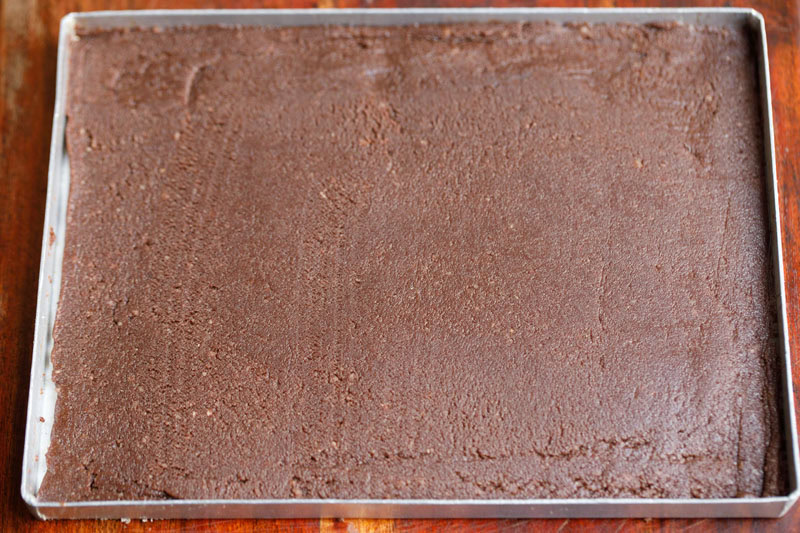 Smooth chocolate barfi mithai in a tray.