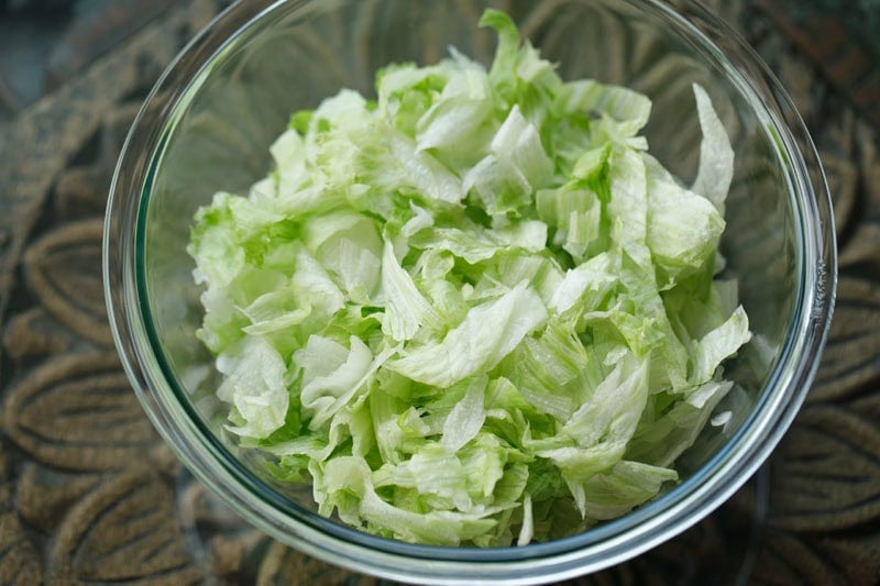 chopped lettuce in a mixing glass bowl.