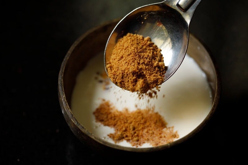 Pouring jaggery into yogurt and milk mixture.