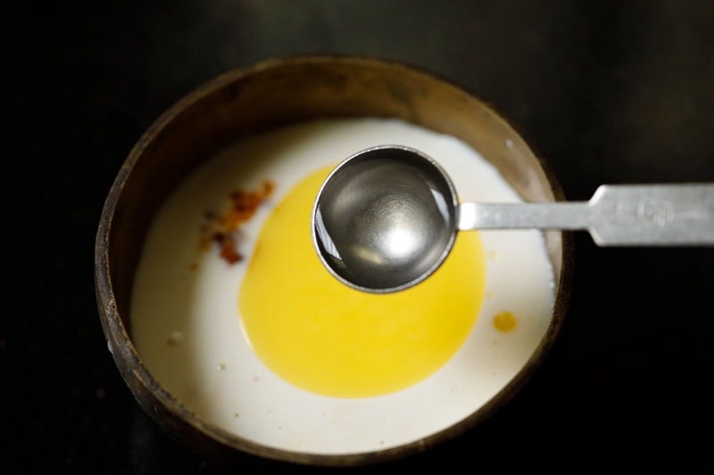 Spoon with ganga jal being poured into the bowl.