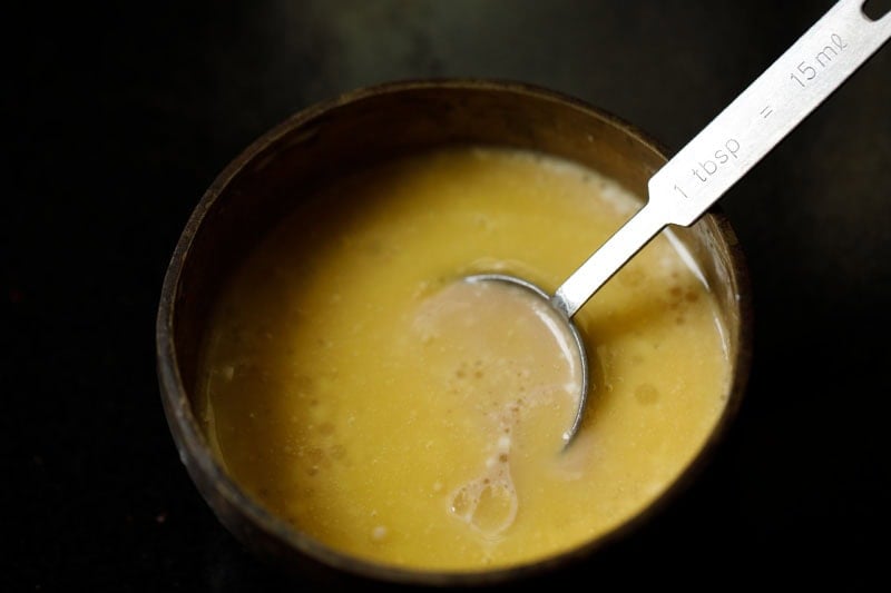 Bowl with a spoon mixing the panchamrut ingedients.