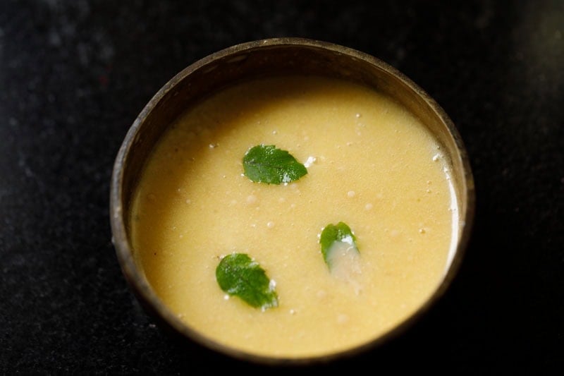 Golden panchamrit in a metal bowl.