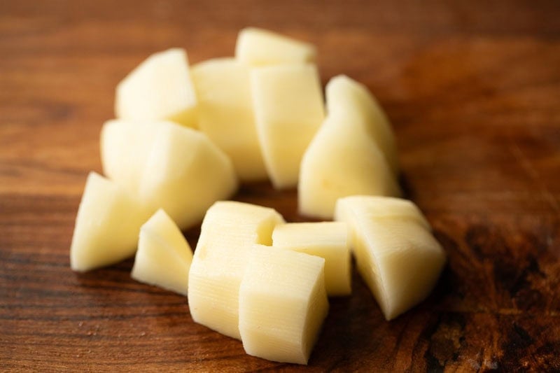 Chopped white potatoes on wooden surface.