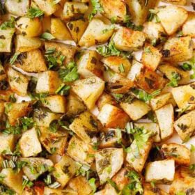 roasted potatoes garnished with parsley on baking tray.