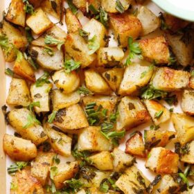 closeup image of roasted potatoes on baking tray with text layovers.