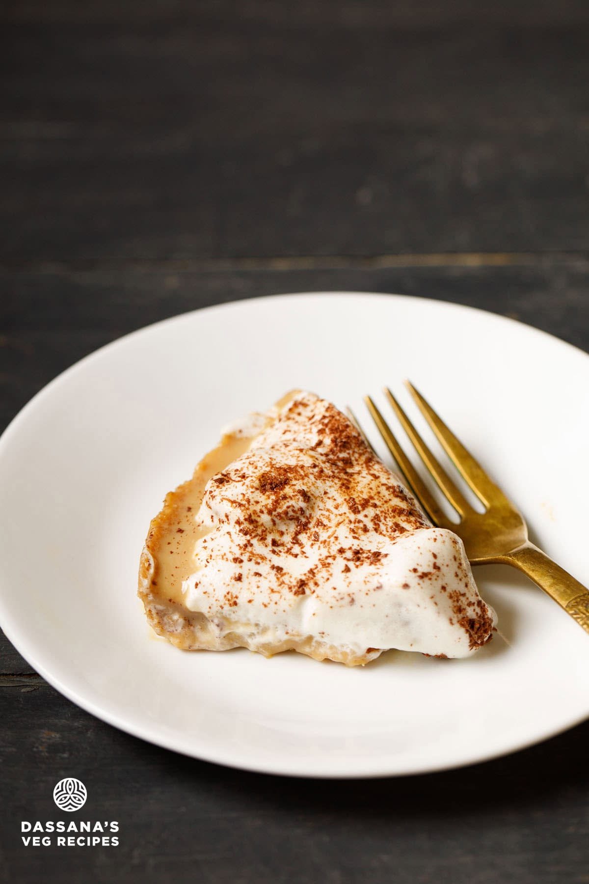 Slice of banoffee pie with golden fork by the side.