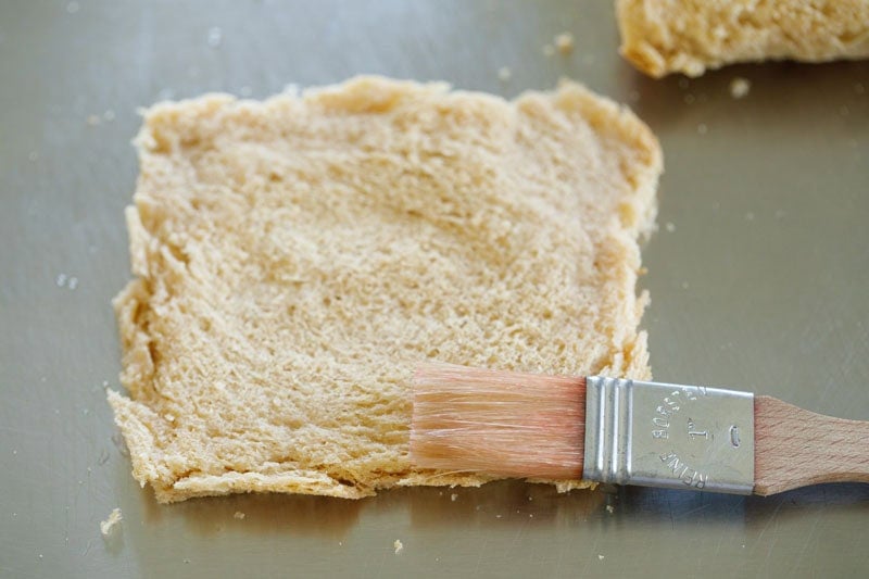 Brushing water on flattened bread.