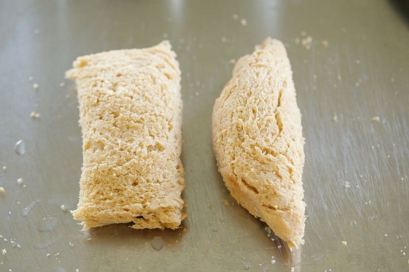 Two pieces of soft bread rolls, envelope shaped and spindle shaped.