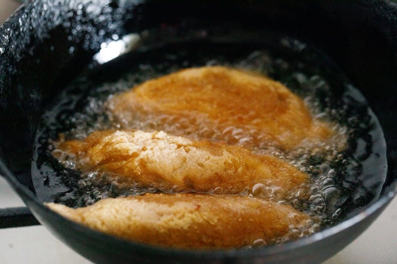 Frying golden brown curd rolls or dahi ke sholay in kadai.