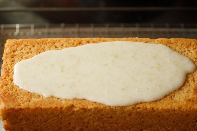 Lemon glaze on lemon cake loaf.