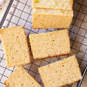 Sliced lemon cake on cooling rack with text layovers.