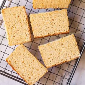 Sliced lemon cake on cooling rack.
