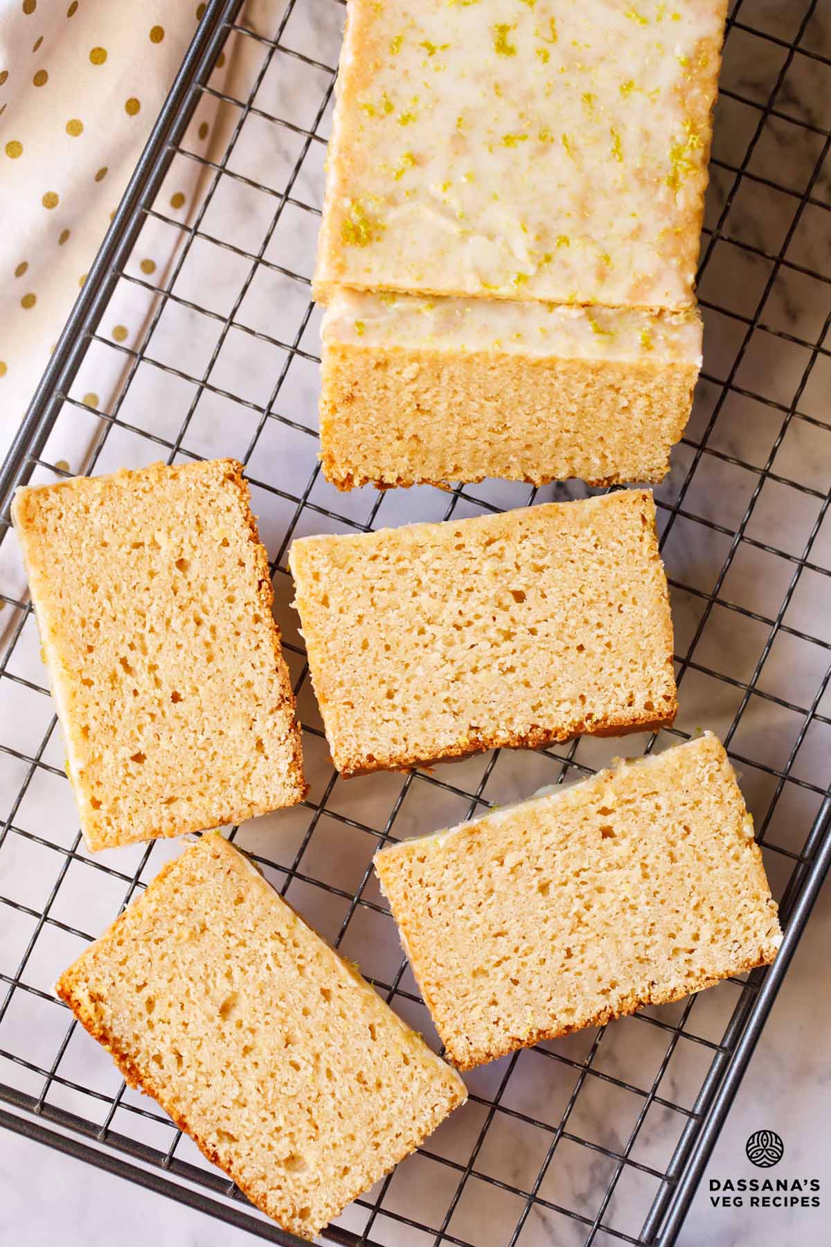 Sliced lemon cake on cooling rack.