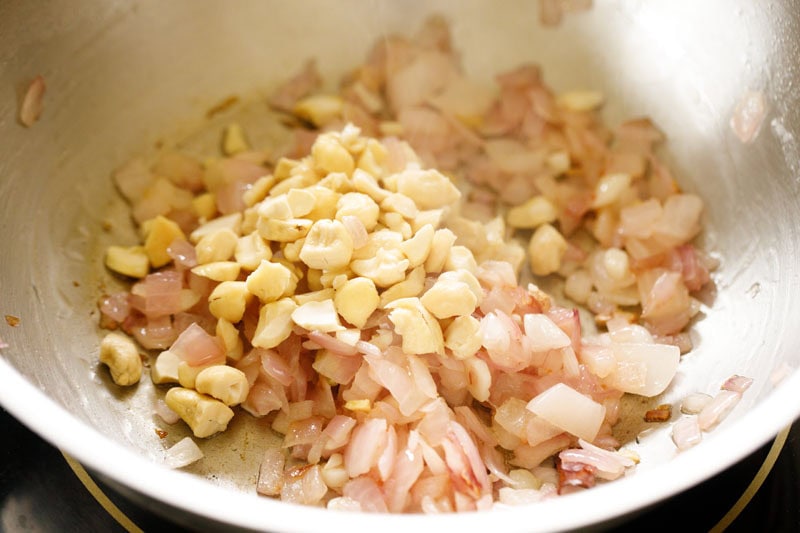 Cashews in the skillet with onions.