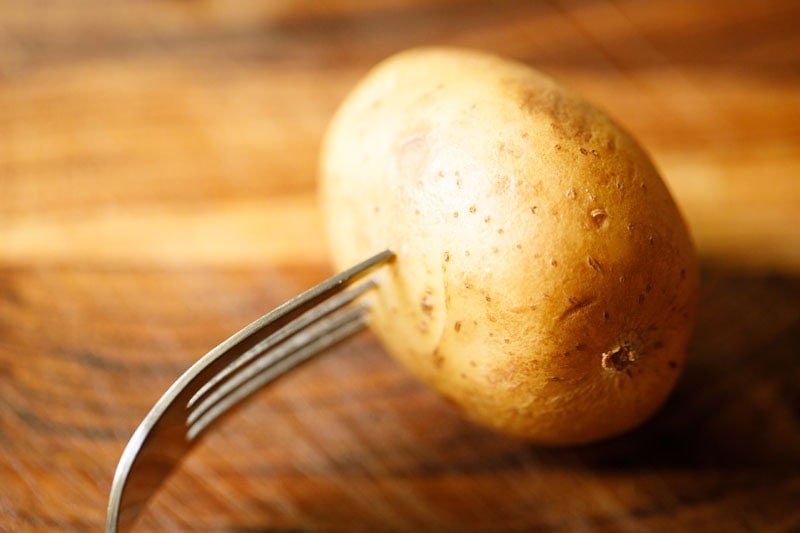 Poking holes in a potato with a fork.