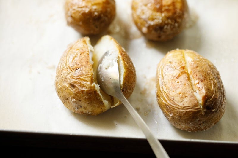 Spoon inside a baked potato.