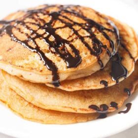 Stack of pancakes with chocolate drizzle.