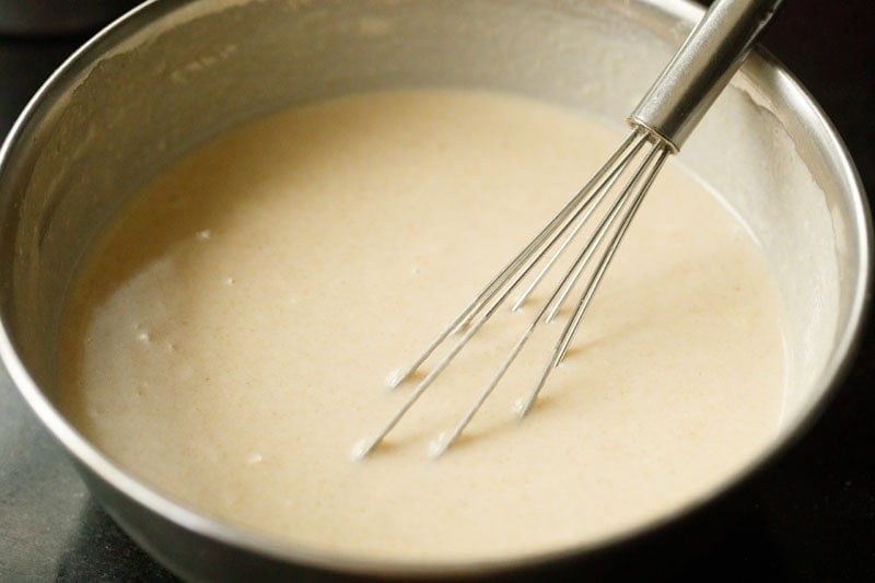 Bowl of pancake batter with whisk.