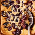 Baked cherry cobbler with spoon.