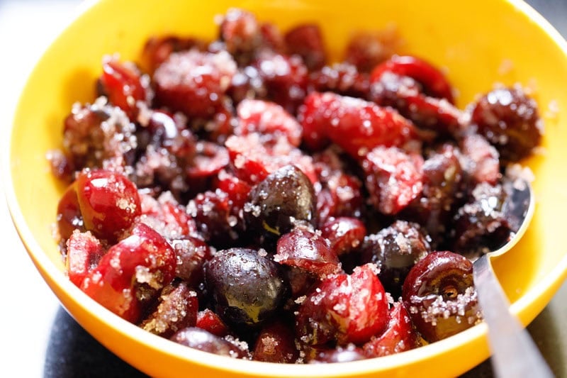 Bowl of mixed cherries and sugar.