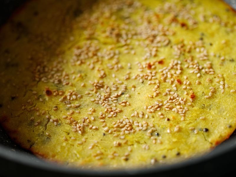 Golden brown savory handvo with sesame.