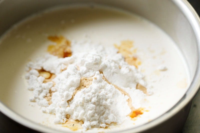Mound of cornstarch with vanilla extract on cream and milk mixture.