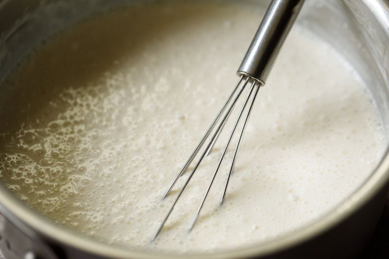 Custard ingredients mixed with wired whisk.