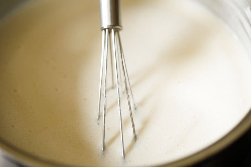 Whisking cooked creme brûlée custard with wired whisk.