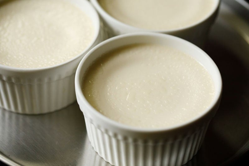 Tiny moisture droplets on surface of custard in ramekins after condensation.