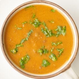 Bowl of lentil soup with herbs.