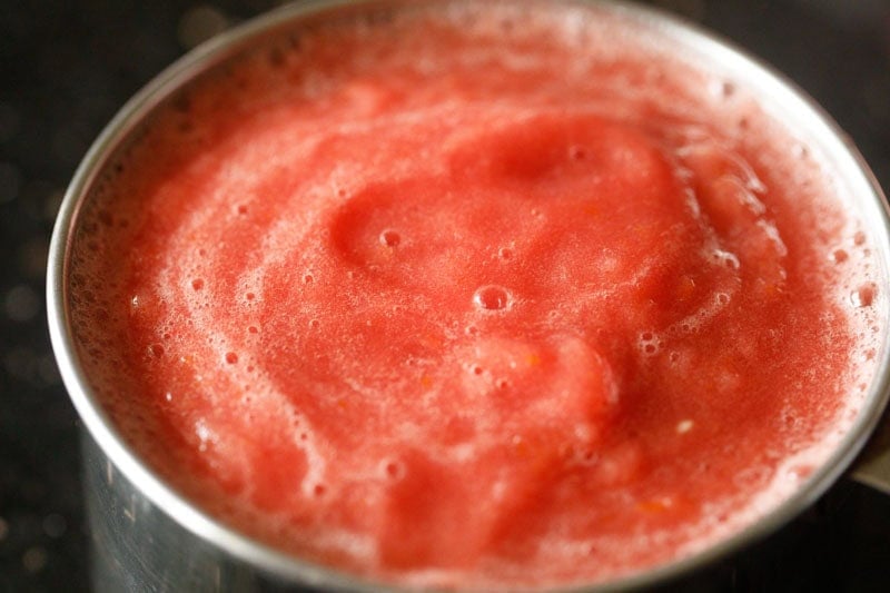 Thick tomato puree in a measuring cup.