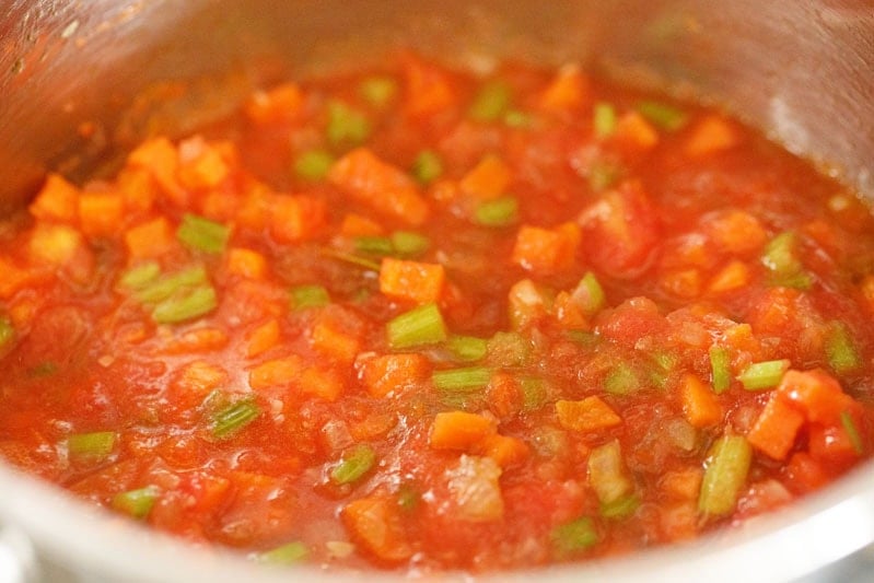 Vegetables mixed with tomato puree in a pot.
