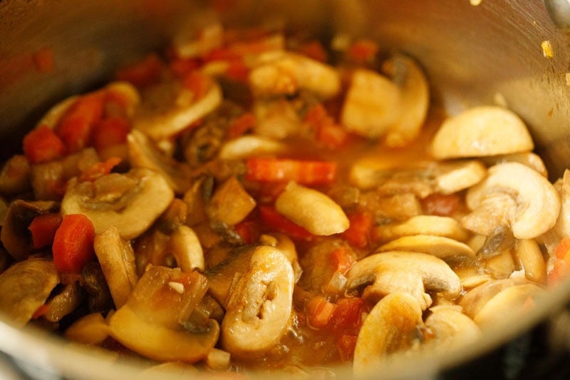 Mushrooms with their liquids in pan.