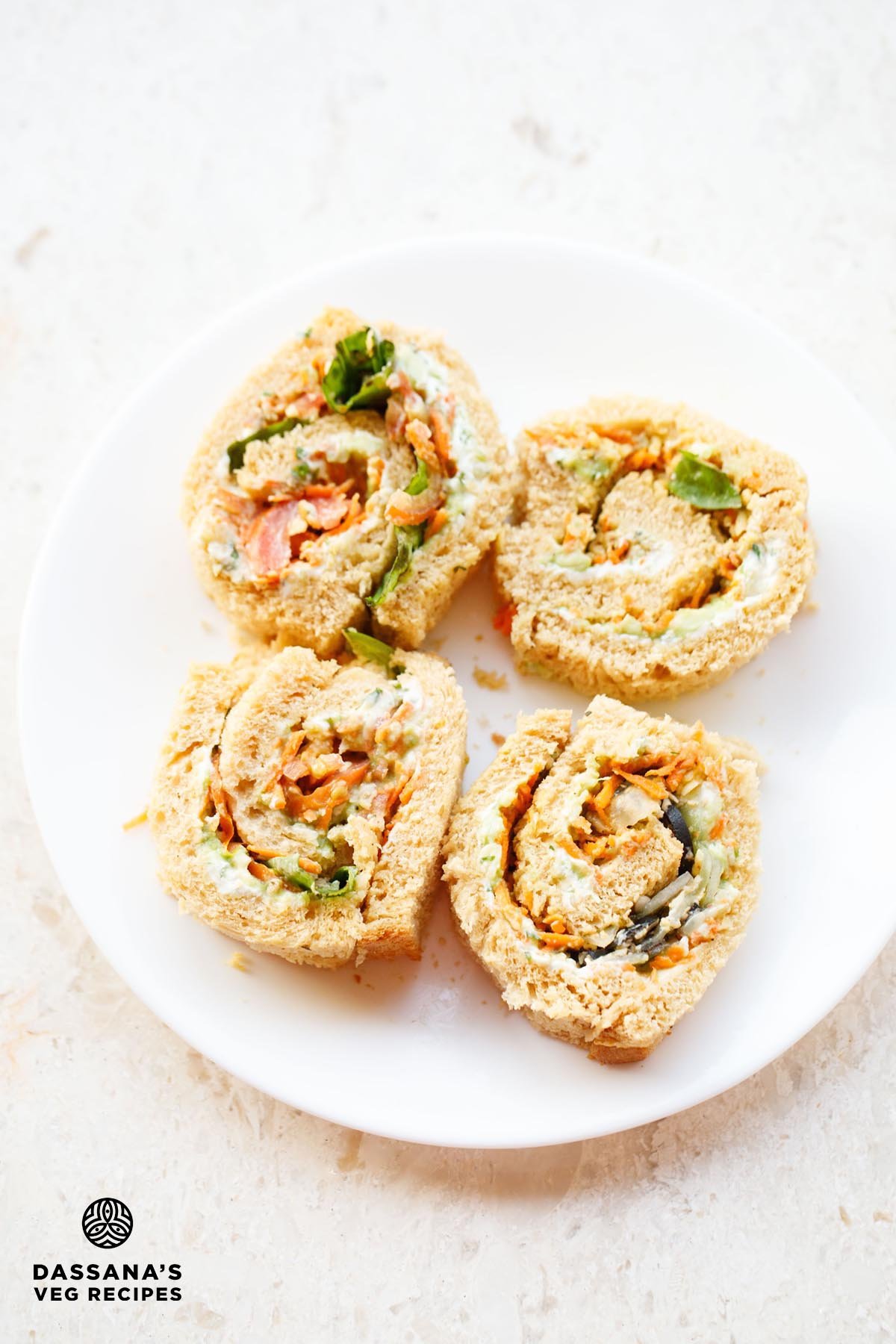 Colorful pinwheel sandwich on white plate.