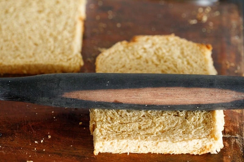 Flattening bread with rolling pin.