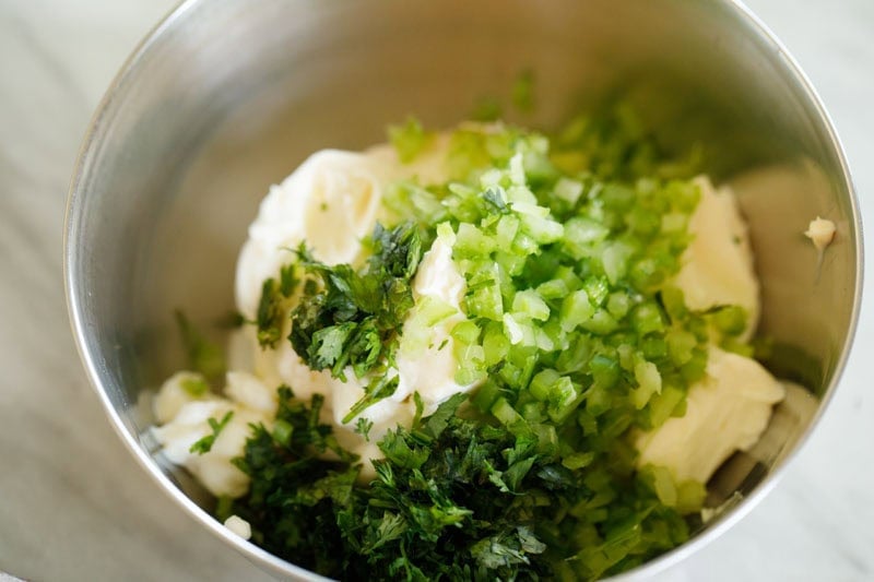 Cream cheese, herbs and seasonings in bowl.