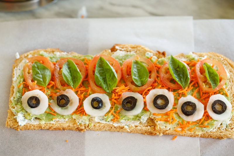 Topped with basil leaves and sliced black olives.