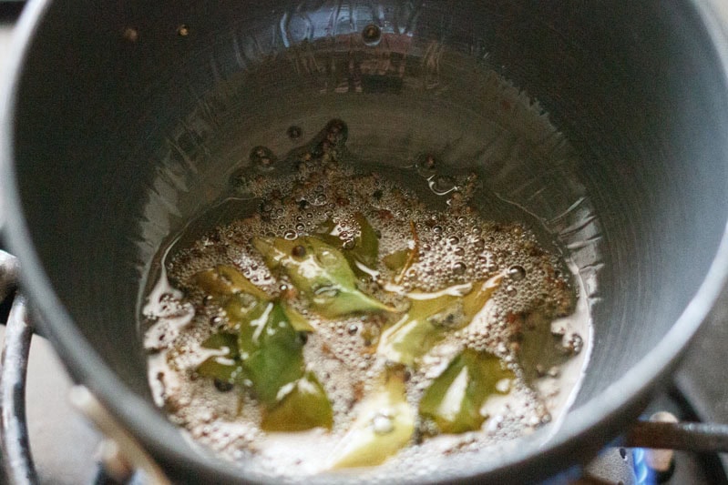 frying mustard seeds, curry leaves and asafoetida in hot oil.