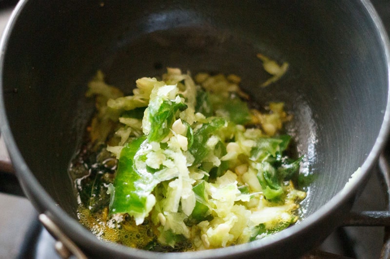 crushed garlic and green chilies, and turmeric powder added to hot oil.