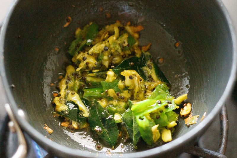 stirring fried herbs and spices in hot oil.