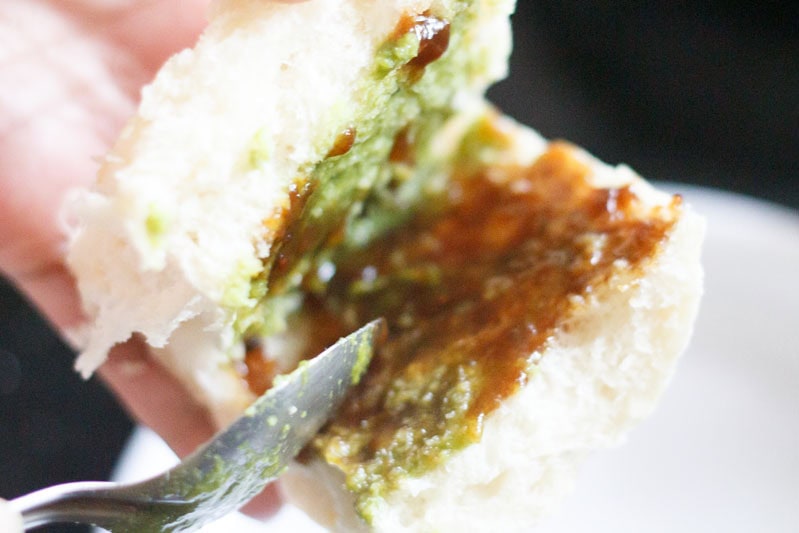 split pav with green chutney and tamarind chutney inside.