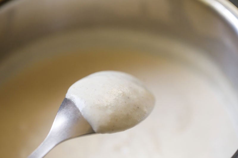 Creamy white sauce coating the back of a spoon.