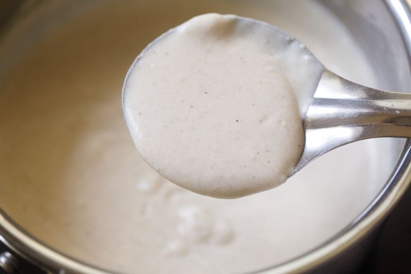 Creamy sauce in metal ladle