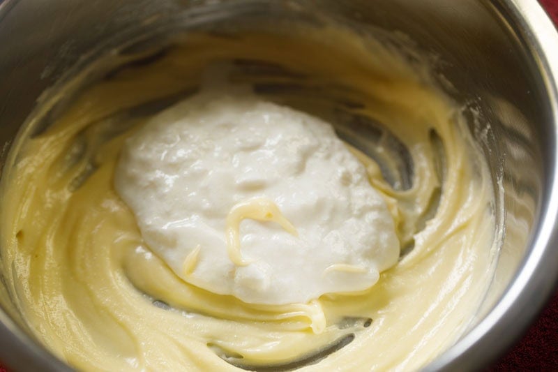 fresh chilled curd added to whisked ghee for making balushahi dough.