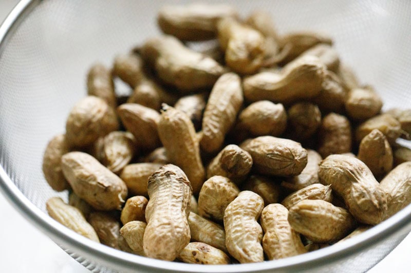 Boiled peanuts in shells in a strainer.
