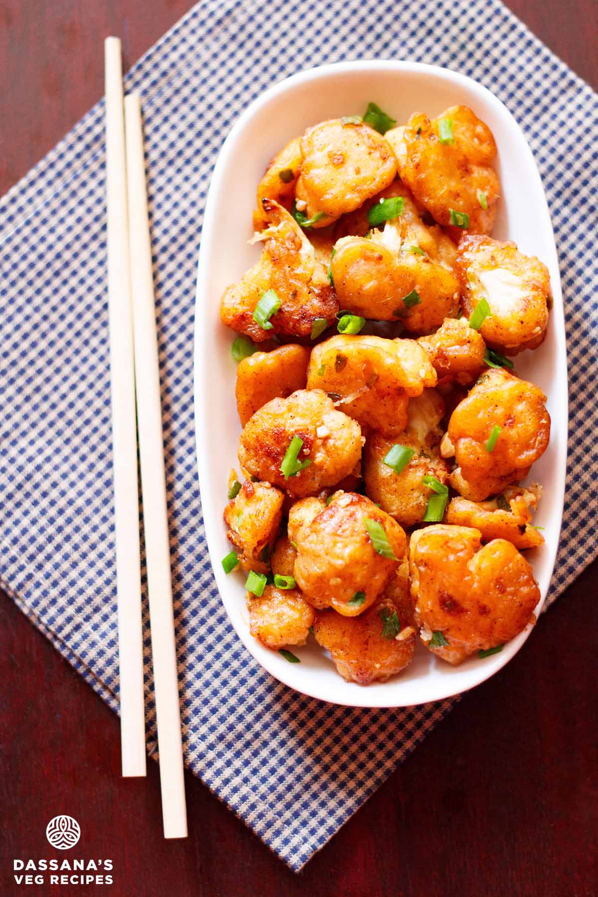 Gobi manchurian with green onions in a white platter.
