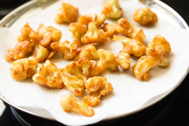 Fried cauliflower pieces on paper towels to make gobi manchurian.