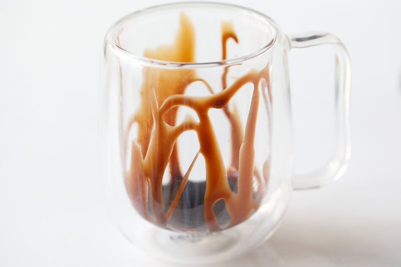 Swirled chocolate syrup in clear glass.