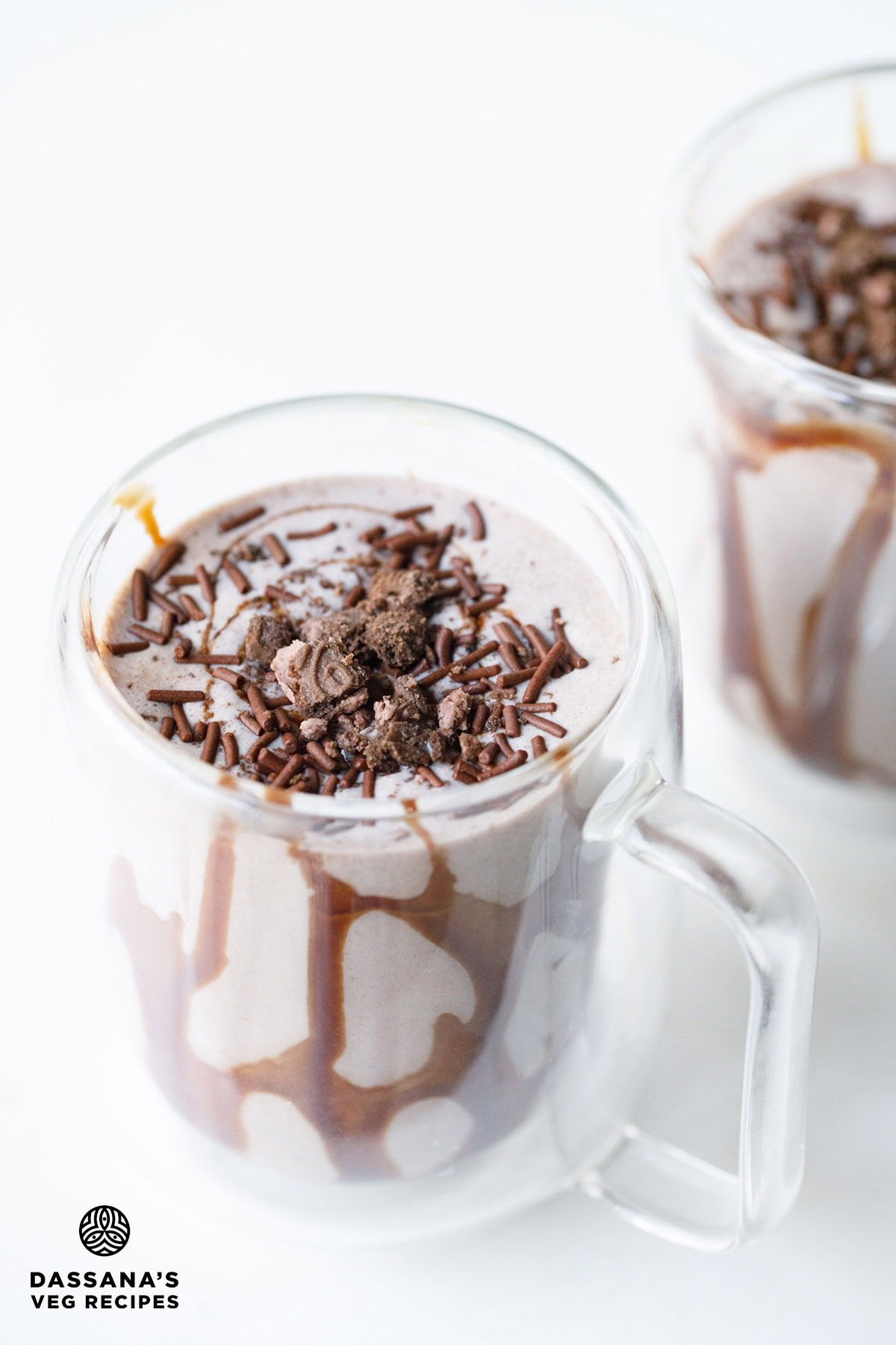 Creamy Oreo shake with sprinkles and crushed Oreo in a clear glass.