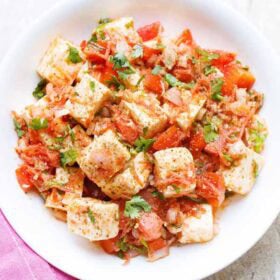 Fresh paneer salad with onions, tomatoes, carrots and herbs.